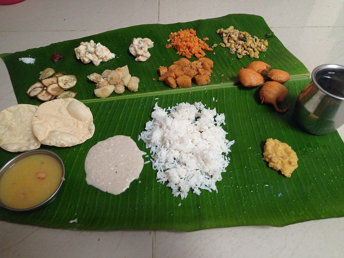 A South Indian meal on a banana leaf with rice, dal, sambar, vegetable dishes, papad and vadai