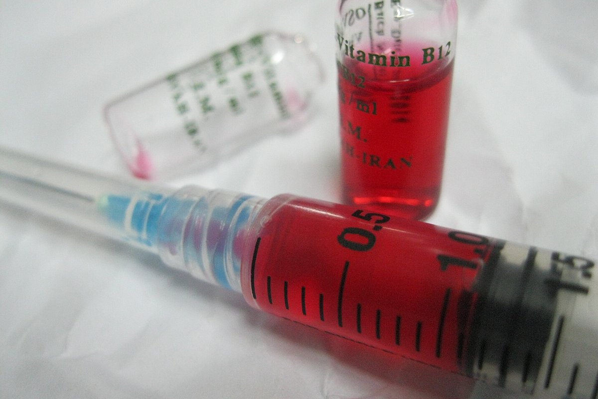 A vial of red vitamin B12 injection and a syringe